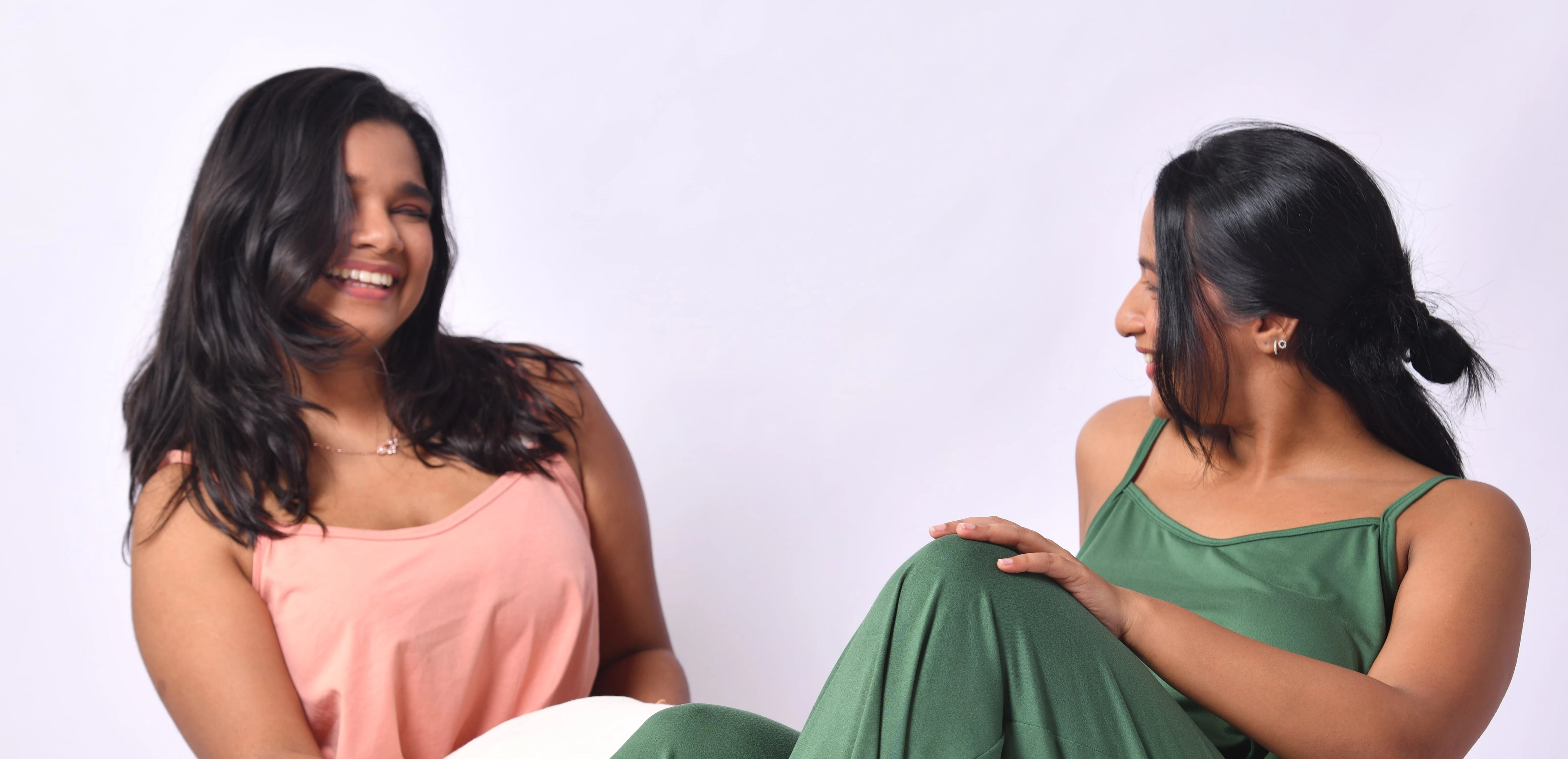 Two motivated, excited founders wearing comfortable sleepwear in pink and green.
