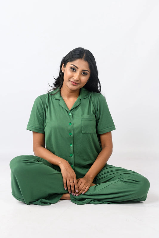 Woman in a green sleeveless pajama set with a flowy top and long pants, perfect for comfortable sleepwear.